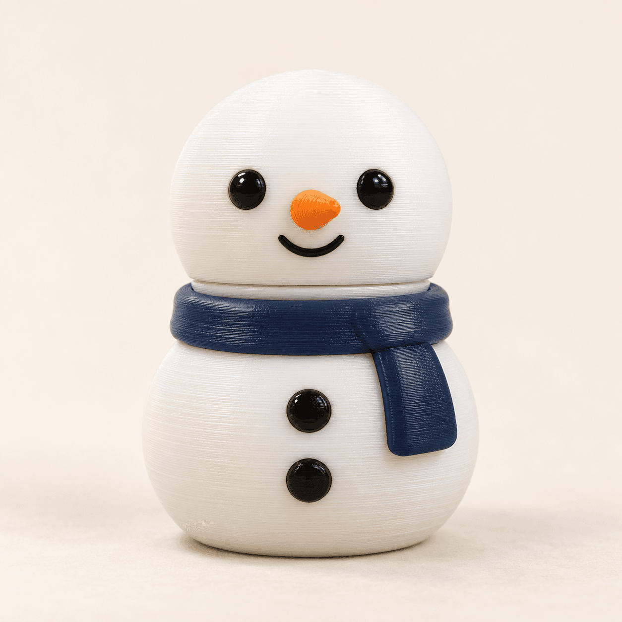 Front studio view of a white Snowman Clicker with a navy scarf and orange nose